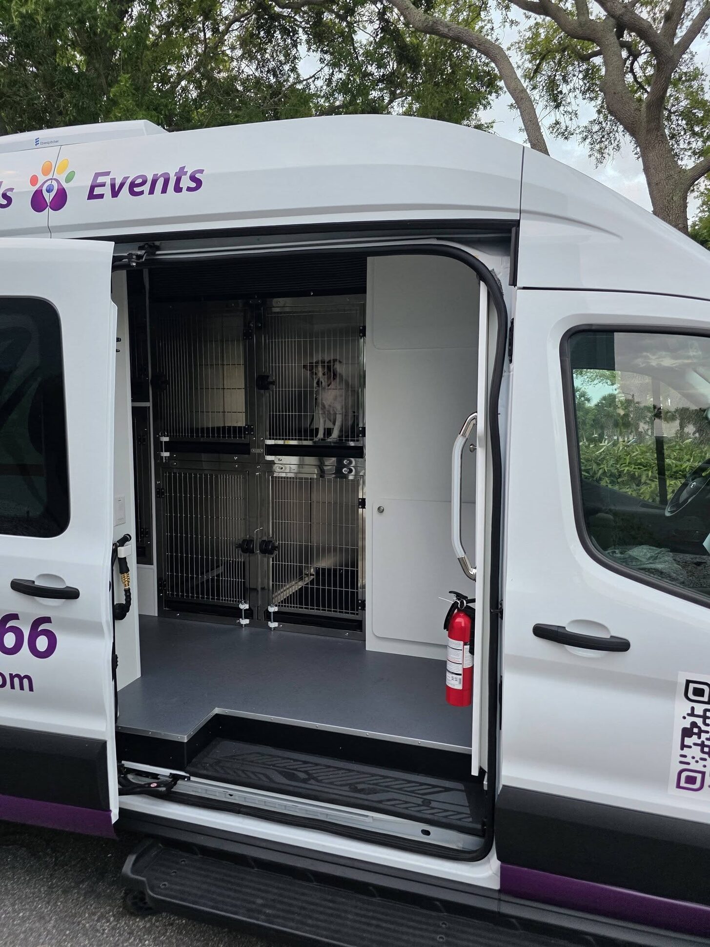 The van’s side door open on its stacked stainless-steel kennels